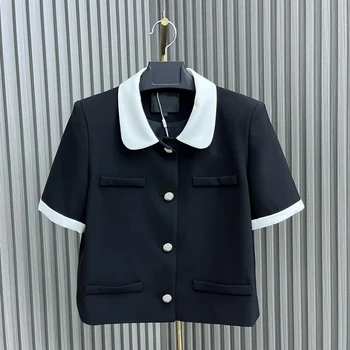Новое маленькое пальто с брошью с коротким рукавом выполнено в классическом черно-белом цветовом контрасте, что придает одежде строгости